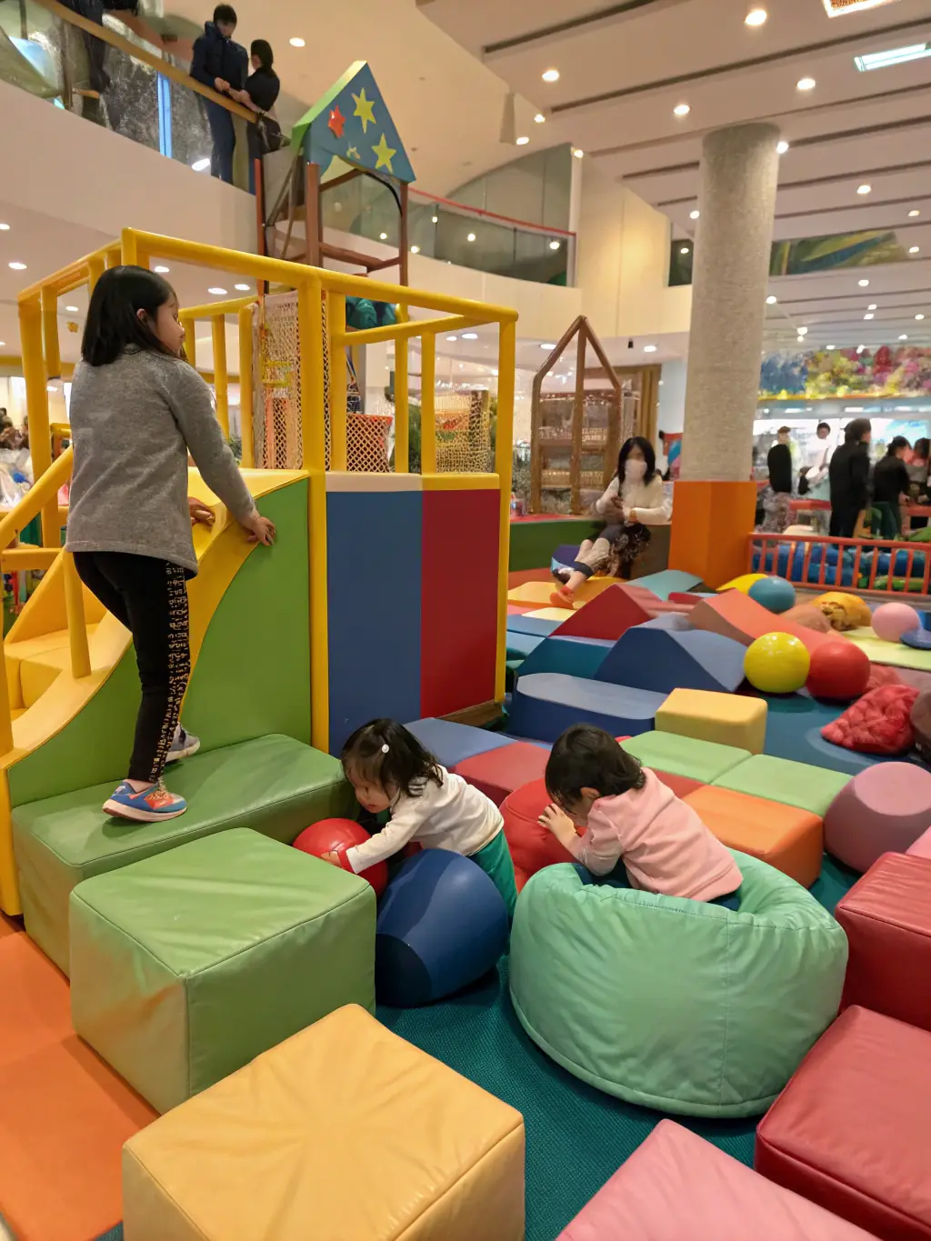 A group of children dressed in various costumes, such as doctors, firefighters, and superheroes, joyfully acting out different scenarios in the Imaginative Play Zone.